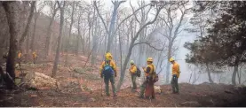  ?? DANIEL FREEL/AP ?? Firefighte­rs with the New Jersey Forest Fire Service monitor remaining pockets of flames in Hardwick, N.J.