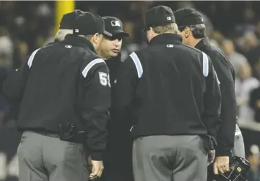  ?? AP FILE PHOTO ?? Umpires huddle after an apparent home run by the New York Yankees' Lance Berkman in the second inning of Game 4 of the American League Championsh­ip Series against the Texas Rangers in New York in October 2016.