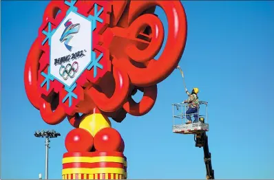  ?? LIU HONGSHENG / FOR CHINA DAILY ?? A worker polishes a giant display for the Beijing 2022 Winter Olympics at Tian’anmen Square in Beijing on Thursday. By Jan 20, more than 200,000 Olympic-themed decorative lanterns, 14,000 signboards and 10 large floral displays will be featured throughout the city.