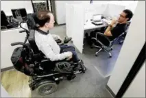  ?? CHRIS CARLSON — THE ASSOCIATED PRESS ?? Miles Thornback, left, who has cerebral palsy, works on marketing campaigns for agents talks with Jordan Wilson at RE/MAX Prestige real estate office in Costa Mesa, Calif.