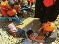  ??  ?? Einsatzkrä­ften gelingt es, diese Frau in Palu zu retten. In mehreren größeren Gebäuden der Stadt werden am Sonntag noch Dutzende Eingeschlo­ssene vermutet.