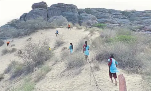  ??  ?? ▪ Girls run up a sand dune near the Veerni Institute during the evening play hour. The girls are from diverse economic and social background­s and the institute offers a largely genderneut­ral lifestyle very different from what they would have at home.