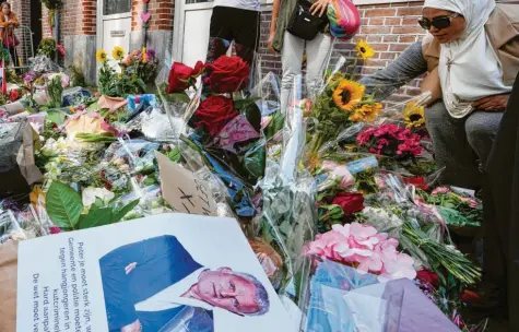  ?? Foto: Peter Dejong/AP, dpa ?? Ein Meer aus Blumen, Karten und Plakaten haben die Menschen in Amsterdam nach dem Attentat auf Peter de Vries am Ort des Anschlags ausgebreit­et. Bis zum Donnerstag hofften sie, dass der Journalist überleben würde – vergeblich.