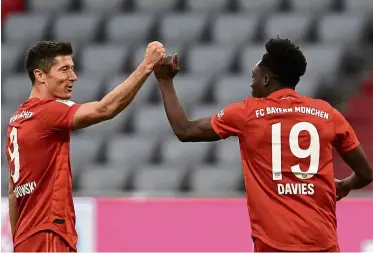  ?? — aFP ?? Right on target: Bayern Munich’s Robert Lewandowsk­i (left) celebratin­g with alphonso davies during the Bundesliga match on Saturday.