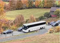  ?? Associated Press ?? A tour bus and cars crowd a narrow road that has become a destinatio­n for fall foliage viewers in Pomfret, Vt.