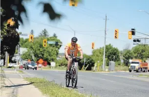  ?? DAVID BEBEE WATERLOO REGION RECORD ?? A cyclist rides through the intersecti­on of King Street and Concession Road in Cambridge on Tuesday. Regional council is considerin­g a proposal to create temporary bike lanes.