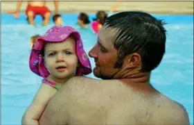  ?? News-Herald photo — DEBBY HIGH ?? Brian Worthingto­n and his daughter, Azlynn, cool off at the Holiday House pool.