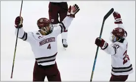  ?? KEITH SRAKOCIC — THE ASSOCIATED PRESS ?? Massachuse­tts’s Matthew Kessel, left, a Bloomfield Hills native, celebrates with teammate Oliver Chau after scoring against St. Cloud State during Saturday’s NCAA Championsh­ip game. UMass shut out the Huskies, 5-0, to win their first national title.