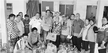  ??  ?? Dennis (sixth left) presenting the food aid from the Welfare Department to the victims.
