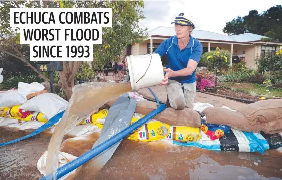  ?? ?? Robyn Mccluskey, 68, at the front gate of her Echuca home surrounded by a sea of rising flood water from the Murray River. Picture: David Caird