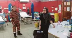  ?? ?? ANGGOTA Bomba dan Penyelamat Kota Marudu memantau premis berisiko di pekan Kota Marudu, Kota Kinabalu selepas gempa bumi lemah bermagnitu­d 3.8 pada skala Richter.
