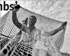  ??  ?? A man repairs a fishing net on his boat on the Tonle Basac River in Phnom Penh, Cambodia, on Jan 20, 2017.