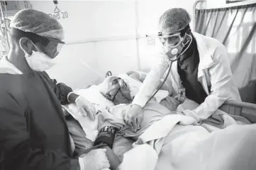  ?? HANI MOHAMMED/AP 2020 ?? Medical workers treat a COVID-19 patient in an intensive care unit at a hospital in Sanaa, Yemen.