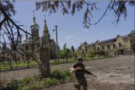  ?? BERNAT ARMANGUE — THE ASSOCIATED PRESS ?? A Ukrainian serviceman patrols a village near the frontline in eastern Ukraine on Thursday.