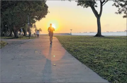  ?? AP FILE ?? A man is seen jogging in a recent Associated Press photo. Researcher­s say exercise helps people better manage chronic pain and its impacts such as how intense pain feels. Exercise also reduces disability, fatigue, depression and anxiety.