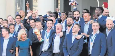  ??  ?? Just champions: the French team’s World Cup celebratio­ns in full swing with President Macron and his wife Brigitte in Paris