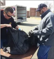  ?? EVAN BRANDT — MEDIANEWS GROUP ?? John Connor, head of buildings and facilities, and Dave Livengood, who heads the career and technical center at the high school, sort food for distributi­on Wednesday outside Lincoln Elementary School.