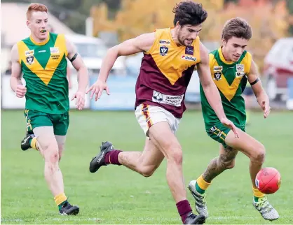  ??  ?? Drouin captain Darcy Irwin leads opponents Josh Hopkins (right) and Grant Flemming to the ball as the Hawks tried to stem the tide against a powerful Leongatha team on Saturday.