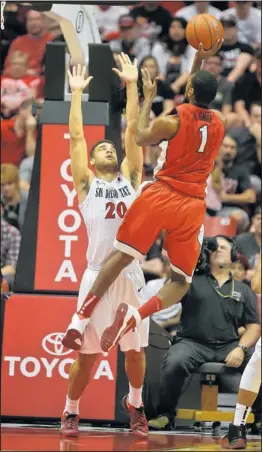  ?? LENNY IGNELZI/THE ASSOCIATED PRESS ?? UNLV forward Roscoe Smith (1) scores over Aztec forward JJ O’Brien (20) during their game Saturday at San Diego State.