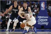  ?? TONY GUTIERREZ — THE ASSOCIATED PRESS ?? Mavericks forward Luka Doncic (77) fouls Warriors guard Ky Bowman in the second half Wednesday in Dallas.