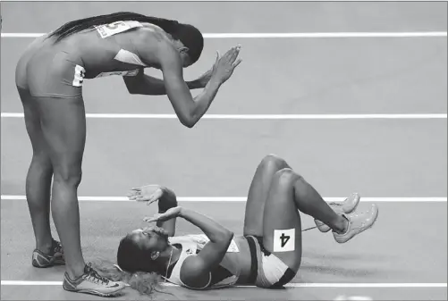  ?? KIRILL KUDRYAVTSE­V / AGENCE FRANCE-PRESSE ?? Jamaica’s Shelly-Ann Fraser-Pryce (bottom) celebrates with Nigeria’s Blessing Okagbare after winning the women’s 200m final on Friday.