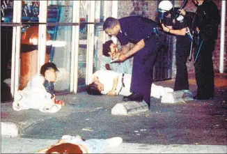  ?? Hyungwon Kang Los Angeles Times ?? EDWARD SONG LEE, foreground, was shot to death and three other Koreans were injured in an exchange of gunfire during the unrest at 3rd Street and Hobart Boulevard on April 30, 1992.