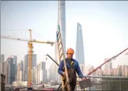  ?? KANG KANG / FOR CHINA DAILY ?? A worker walks through the constructi­on site of a commercial property project in Pudong New Area of Shanghai.