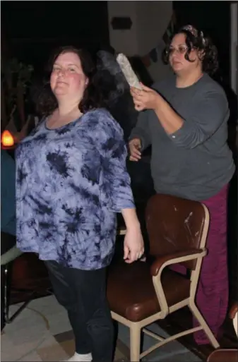  ?? PHOTOS BY MICHILEA PATTERSON — FOR DIGITAL FIRST MEDIA ?? Kristen Peek, of Barto, gets cleansed with a burning sage stick by Nikole Ackley, the owner of the Spirit Holistic Center in Boyertown. The ritual is used to get rid of low energy and negative thoughts.