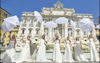 ?? AFP ?? LET US TIE THE KNOT: Women hold a protest by the Trevi fountain in Rome against the postponeme­nt of their weddings due to strict curbs on ceremonies amid the coronaviru­s pandemic.
