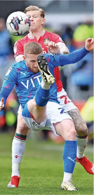  ?? Ben Roberts Photo ?? ●●Connor Lemonheigh-Evans clears the ball with James McClean of Wrexham closing in