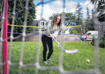  ?? CP PHOTO ?? Julia van Damme, 12, who was diagnosed with a low-grade glioma brain tumour after a routine eye exam plays hockey recently in her backyard in Mississaug­a, Ont.