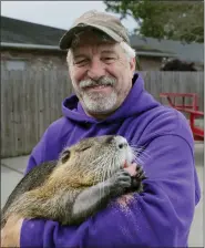  ?? DAVID GRUNFELD — THE TIMES-PICAYUNE — THE NEW ORLEANS ADVOCATE VIA AP ?? Denny Lacoste holds a rescued baby nutria March 13in Metairie, La