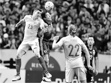  ??  ?? Australia’s Tomas Rogic (left) and Japan’s Makoto Hasebe fights for the ball during the group B World Cup 2018 qualifying match in Saitama. — Reuters photo