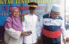  ??  ?? ILMAN Hakim meraikan kejayaan merangkul hadiah Menteri Pertahanan bersama keluarga di Padang Kawad Kem Sungai Besi.