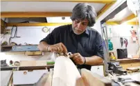  ?? AFP ?? Indian bat maker Aslam Chaudhry is seen shaving wood from a cricket bat at his workshop in Mumbai. —