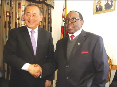  ?? — Picture by Kudakwashe Hunda ?? Acting Foreign Affairs Minister Simon Khaya Moyo and UNESCO Assistant Director-General for Education Mr Qian Tang pose for a picture after the UN official paid a courtesy call at his Munhumutap­a Office in Harare yesterday.