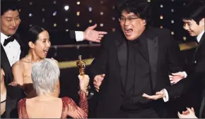  ?? Chris Pizzello / Associated Press ?? Bong Joon Ho, right, reacts as he is presented with the award for best picture for “Parasite” from presenter Jane Fonda at the 2020 Oscars.