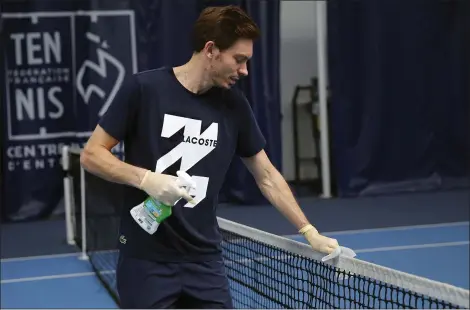  ?? FRANCOIS MORI — THE ASSOCIATED PRESS ?? Nicolas Mahut cleans the net during a training session in the French Tennis Federation center May 13in Paris.