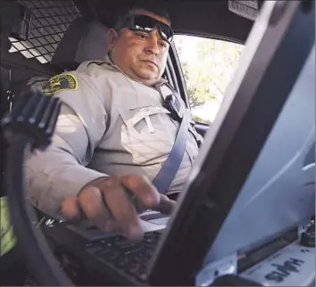  ?? Katie Falkenberg Los Angeles Times ?? WHILE HIS PATROL car is stopped in the City of Industry, Los Angeles Sheriff’s Deputy Ivan Davanzo checks his computer. The department is tightening its guidelines for deputies’ use of the in-car devices.