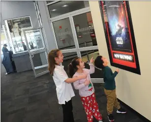  ?? Ernest A. Brown photo ?? FROM LEFT: Hailey Brien, 9; Harper Brien, 5; and Elijah Carpentier, 4; all of Douglas, Mass., check out the movie poster for ‘Star Wars: The Rise of Skywalker’ on display outside Cinemaworl­d in the Lincoln Mall Friday.