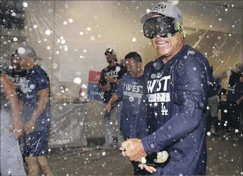  ?? DAVE ROBERTS Christian Petersen Getty Images ?? pops champagne with his Dodgers team in the locker room, a welcome return for them after their title streak was stopped last year.