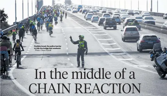  ?? Photo / Dean Purcell ?? Cyclists break the police barrier to ride the bridge last weekend.