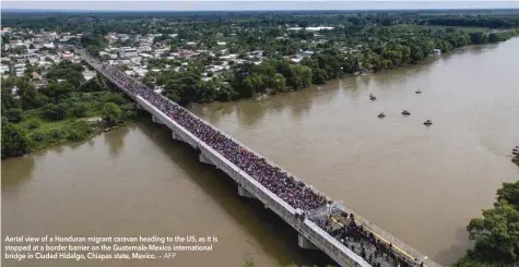  ?? Aerial view of a Honduran migrant caravan heading to the US, as it is stopped at a border barrier on the Guatemala-mexico internatio­nal bridge in Ciudad Hidalgo, Chiapas state, Mexico. ?? — AFP