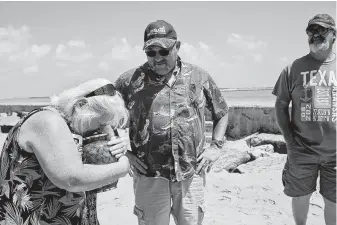  ??  ?? Michelle Shields kisses the urn holding the ashes of her mother, Lula White, on July 2 before spreading them in the surf from a jetty in Port Aransas. It would have been White’s birthday.