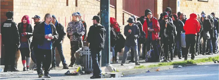  ?? NICK PROCAYLO ?? People line up for welfare cheques in the Downtown Eastside in March. Vancouver City Council says social assistance increases made during COVID should be here to stay.