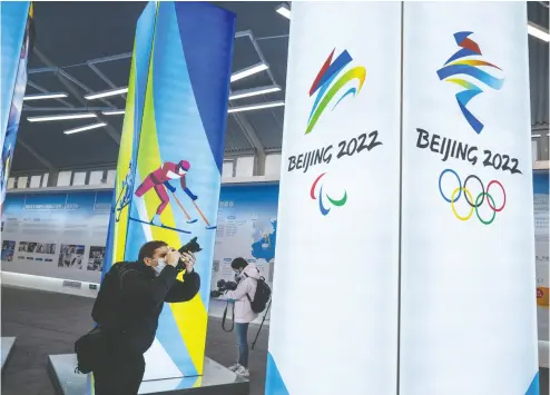  ?? KEVIN Frayer / GETTY IMAGES ?? A journalist last week takes pictures of a display at the exhibition centre for the Beijing 2022 Winter Olympics.