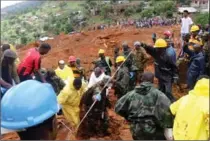  ?? THE ASSOCIATED PRESS ?? Red Cross volunteers dig for survivors at the scene of heavy flooding and mudslides in Regent, just outside of Sierra Leone’s capital Freetown.