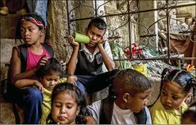  ??  ?? Children wait to eat lunch at Alimenta La Solidarida­d’s soup kitchen. Oil sanctions could lead to a 26 percent reduction in the size of Venezuela’s economy, which is already just half as big as it was in 2013, the year when Maduro took power.