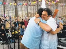  ??  ?? Arturo O’farrill (right) and Jorge Francisco Castillo hug after performing at the border. The 2018 Fandango Fronterizo music festival at the U.s.-mexico border wall.