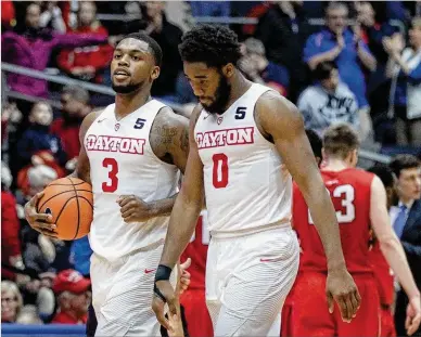  ?? DAVID JABLONSKI / STAFF ?? Trey Landers (left) and Josh Cunningham, walking off Tuesday after the victory over Davidson, will face Saint Louis today with 10 games left in Atlantic 10 play and the Flyers (10-10, 4-4) one game out of third place.